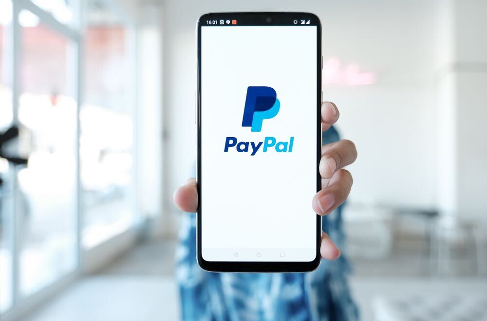 Woman hands holding Oneplus 6 with PayPal apps on the screen. PayPal is an online electronic payment system.