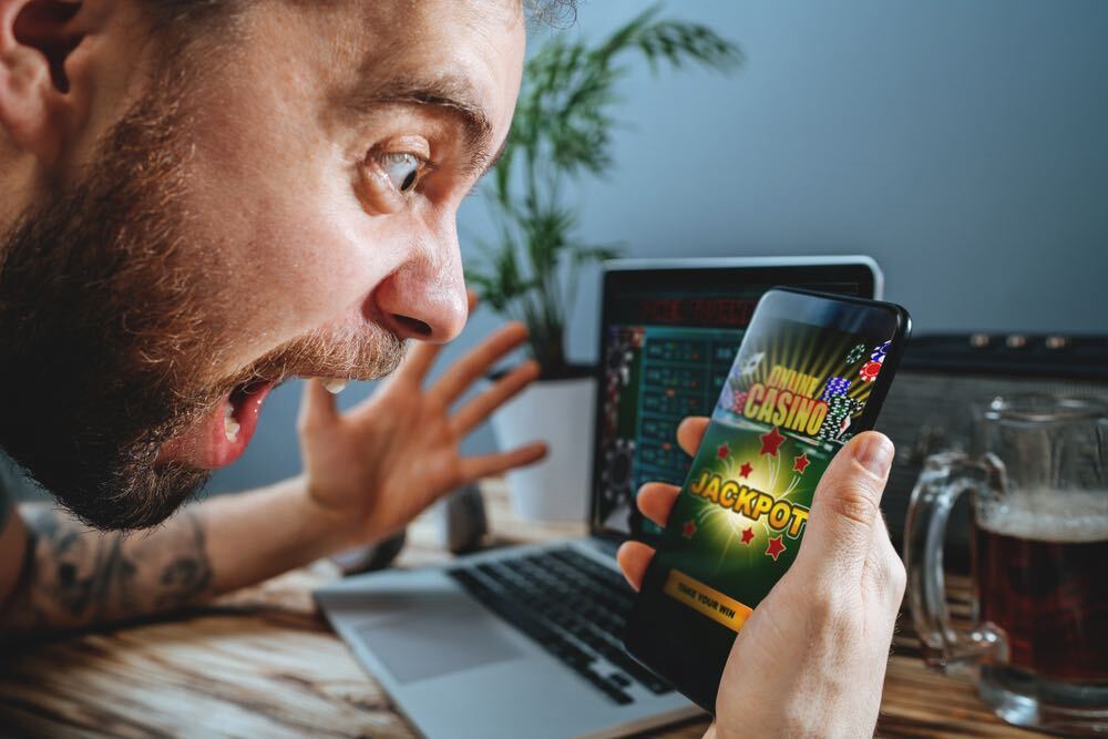 Lucky man celebrating victory after winning jackpot in online casino.